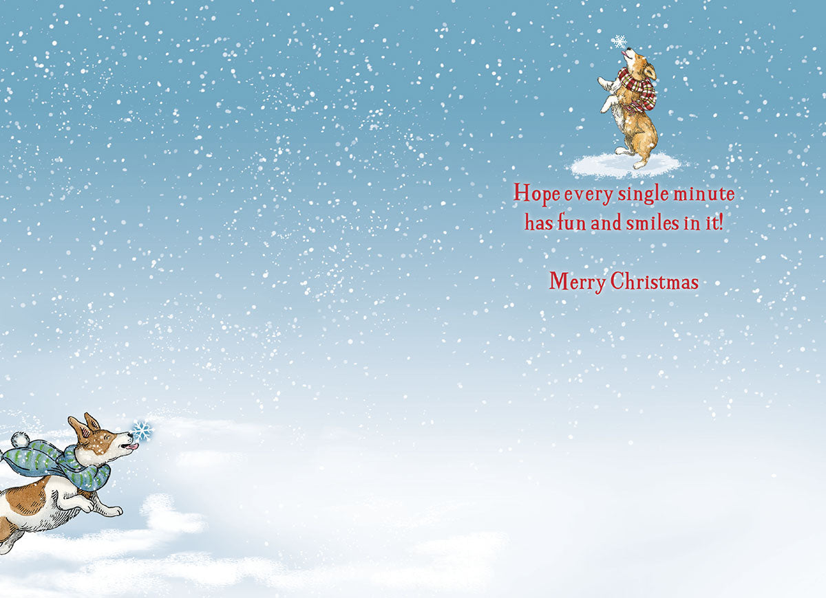 Inside of a Christmas greeting card with a small dog jumping for a snowflake and the message: 'Hope every single minute has fun and smiles in it! Merry Christmas'.