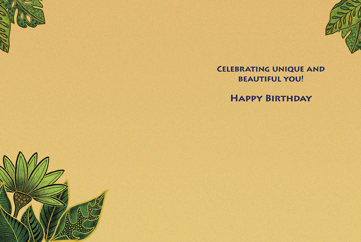 Inside of a light tan birthday card with green tropical leaves in corners. Text: 'CELEBRATING UNIQUE AND BEAUTIFUL YOU! HAPPY BIRTHDAY'.