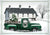 antique green truck with christmas tree in front of white barn