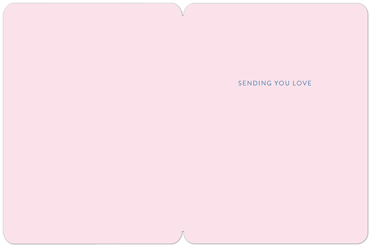 Inside a soft pink greeting card, blue text reads 'SENDING YOU LOVE' on the right panel, offering a warm, comforting message.