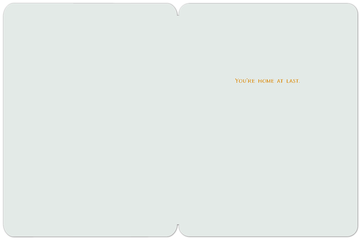 Inside of a new home card with the text 'YOU'RE HOME AT LAST.' in orange on a simple light blue background.