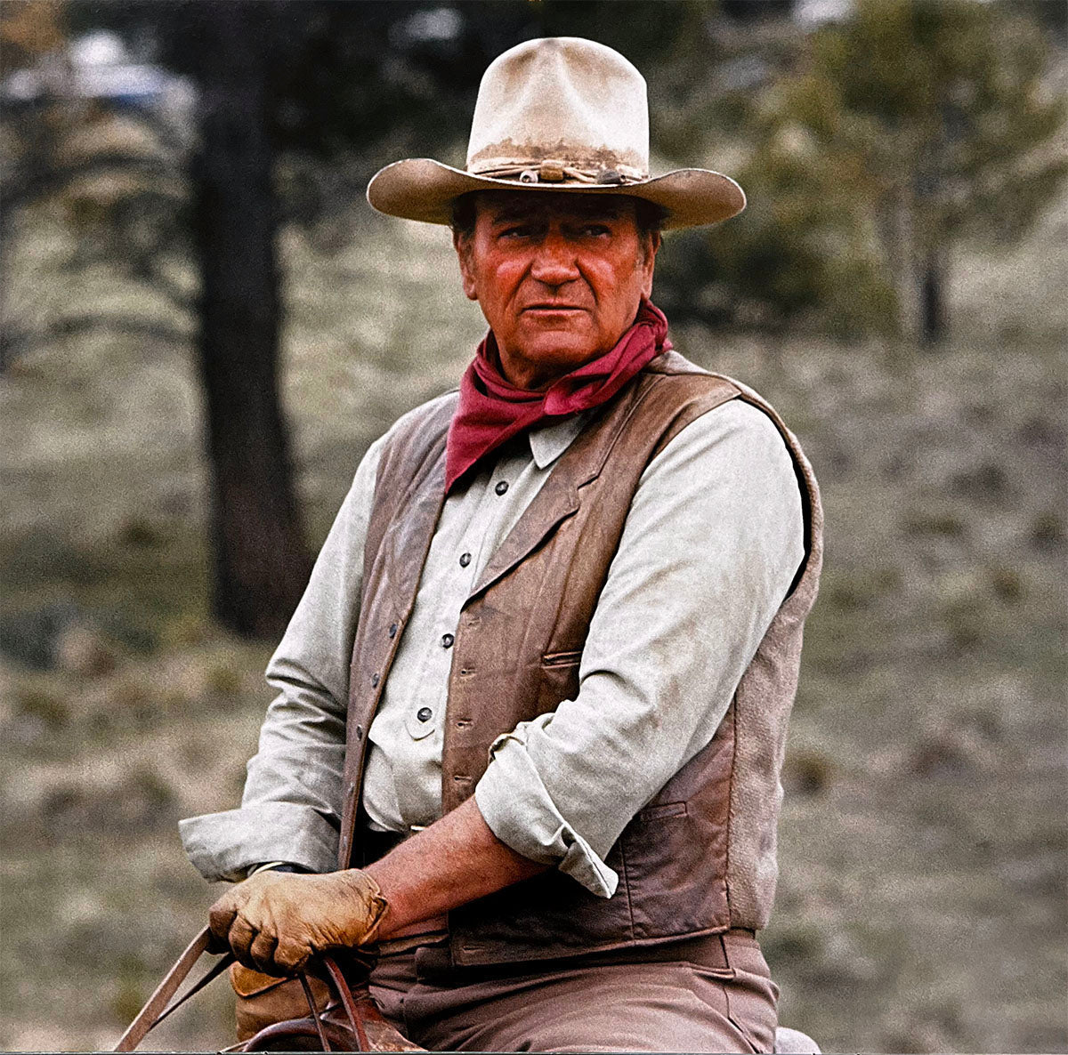 Iconic image of John Wayne on horseback in full cowboy attire with a red bandana, perfect for western calendar fans.