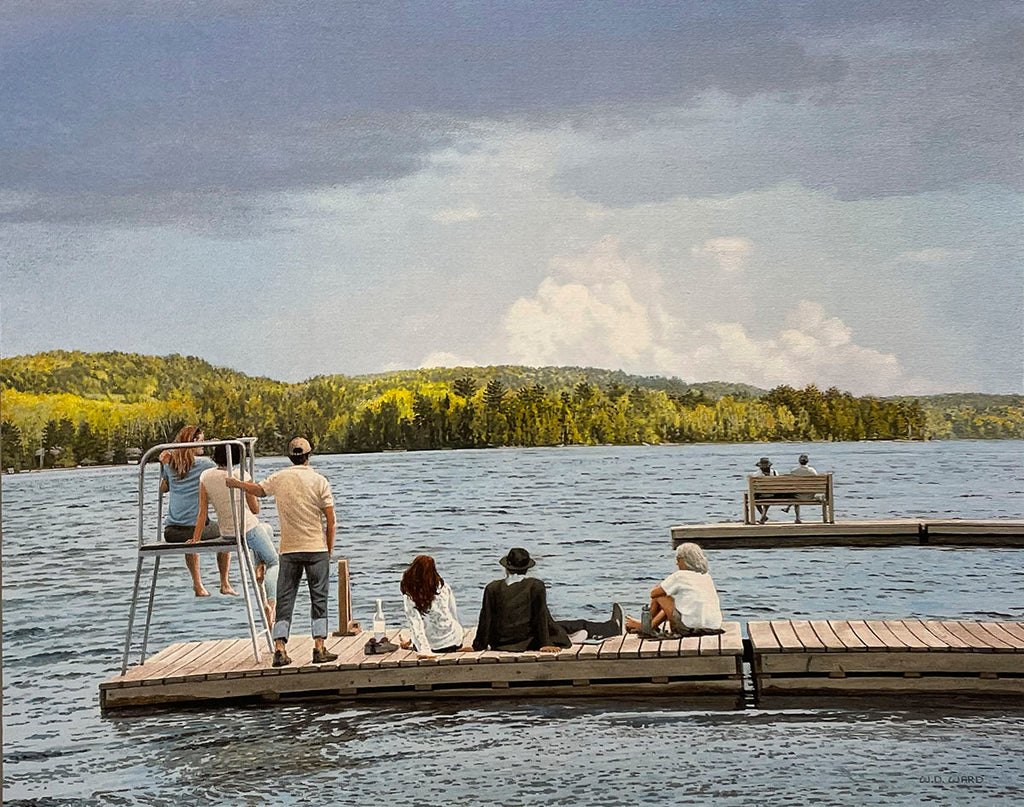 Peaceful lake scene with people relaxing on wooden docks, surrounded by calm water and a lush green landscape.