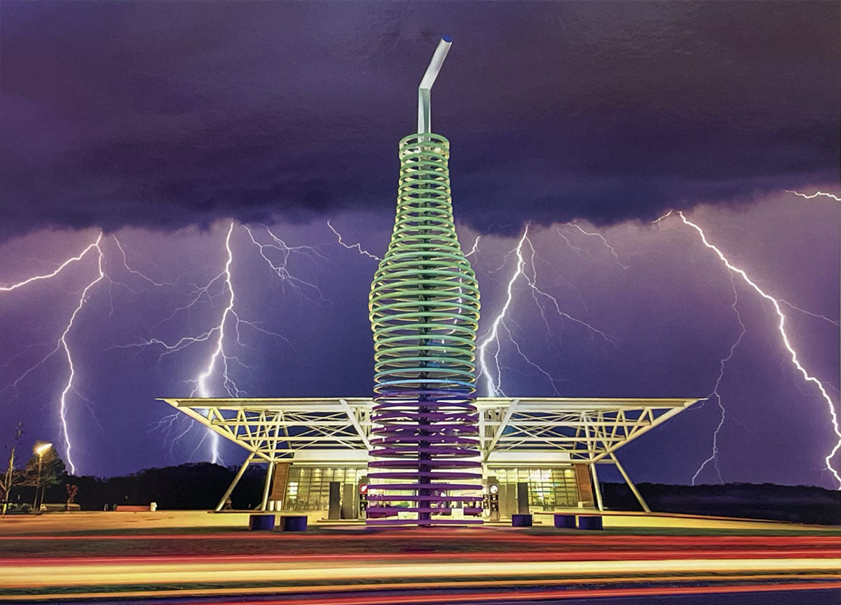 Iconic Pop's Soda Ranch with giant soda bottle sculpture under dramatic lightning storm, Route 66 landmark.