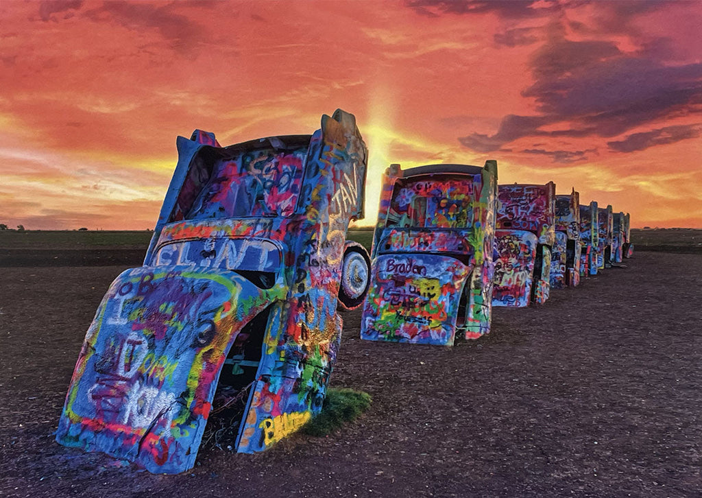 Vibrant Cadillac Ranch art installation at sunset, graffiti-covered vintage cars buried nose-down in a field.