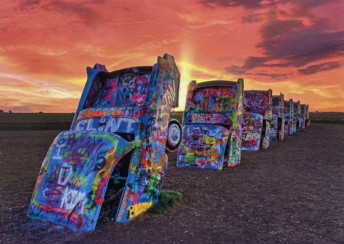 Vibrant Cadillac Ranch art installation at sunset, graffiti-covered vintage cars buried nose-down in a field.