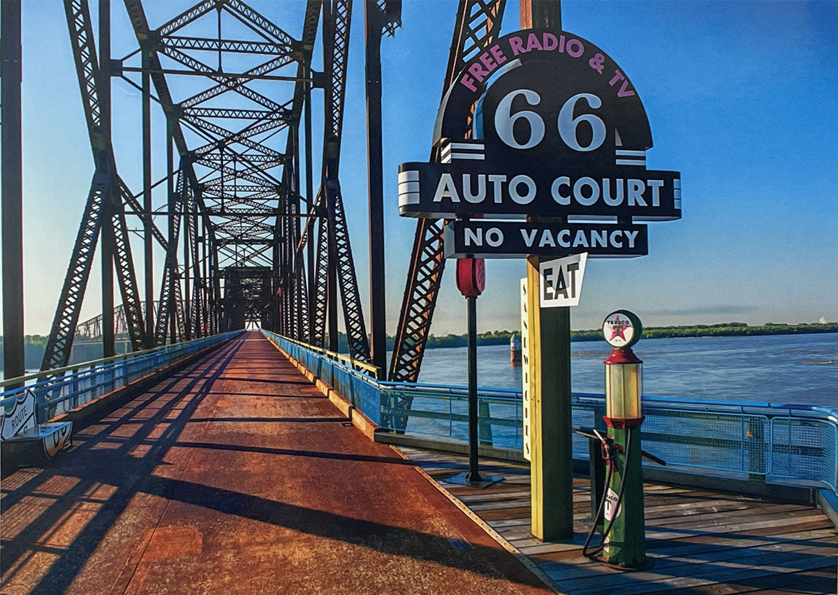 Historic Chain of Rocks Bridge with a 'Route 66 Auto Court' sign and a classic gas pump on a sunny day.