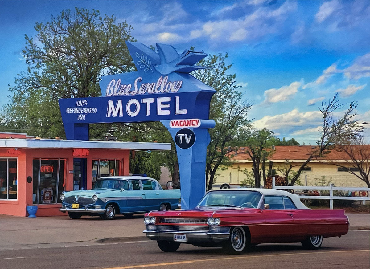 Nostalgic Blue Swallow Motel sign, iconic Route 66 landmark, with classic automobiles parked outside.