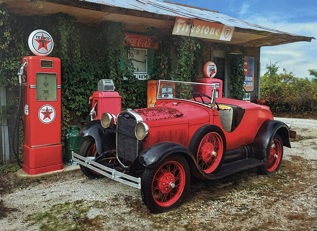Striking red vintage Ford Model A roadster parked beside retro Texaco gas pumps at an abandoned station.