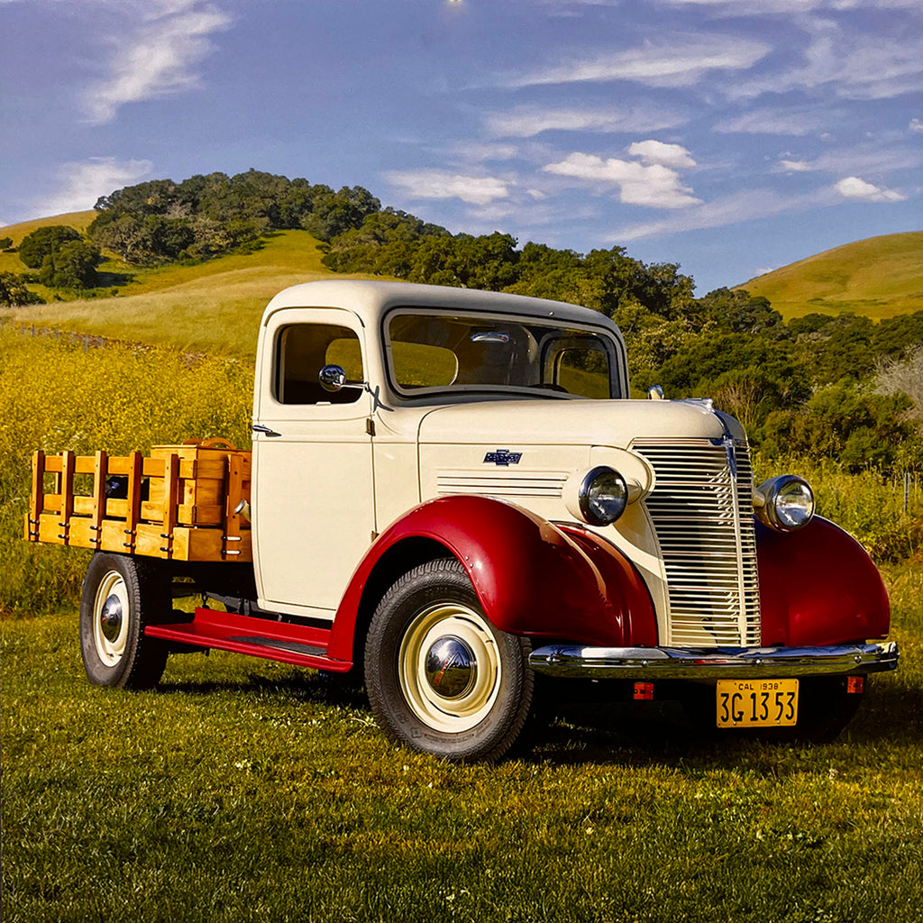 A charming cream and red 1938 Chevrolet Master Sedan Delivery truck with a wooden cargo bed, parked in a sun-drenched green field, capturing the essence of pre-war American automotive design.