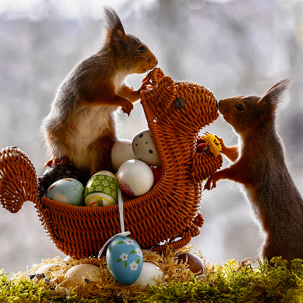 Two cute squirrels interacting with a charming wicker basket full of colorful decorative Easter eggs, creating a heartwarming scene for a holiday-themed month in a calendar.
