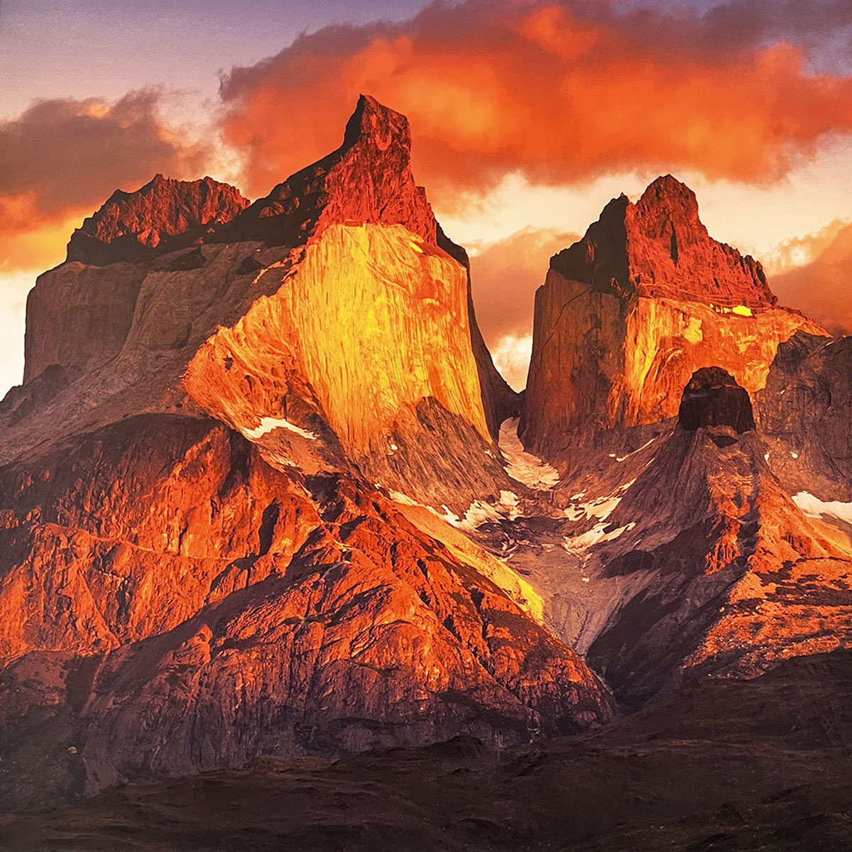 Dramatic sunset over rugged mountain peaks in a wall calendar, showcasing vibrant orange and red clouds illuminating the jagged rock formations. SEO: sunset mountains, dramatic landscape, fiery sky, rugged peaks, nature photography calendar.