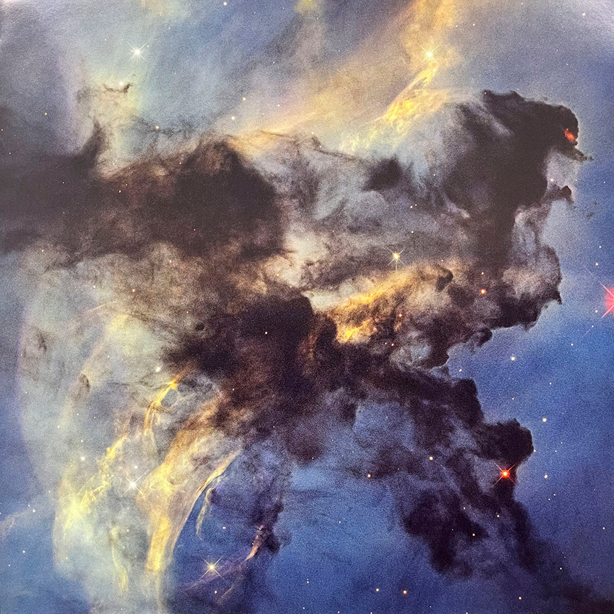 Dramatic, intricate dark nebula formations silhouetted against a luminous background of blue and golden starfields.