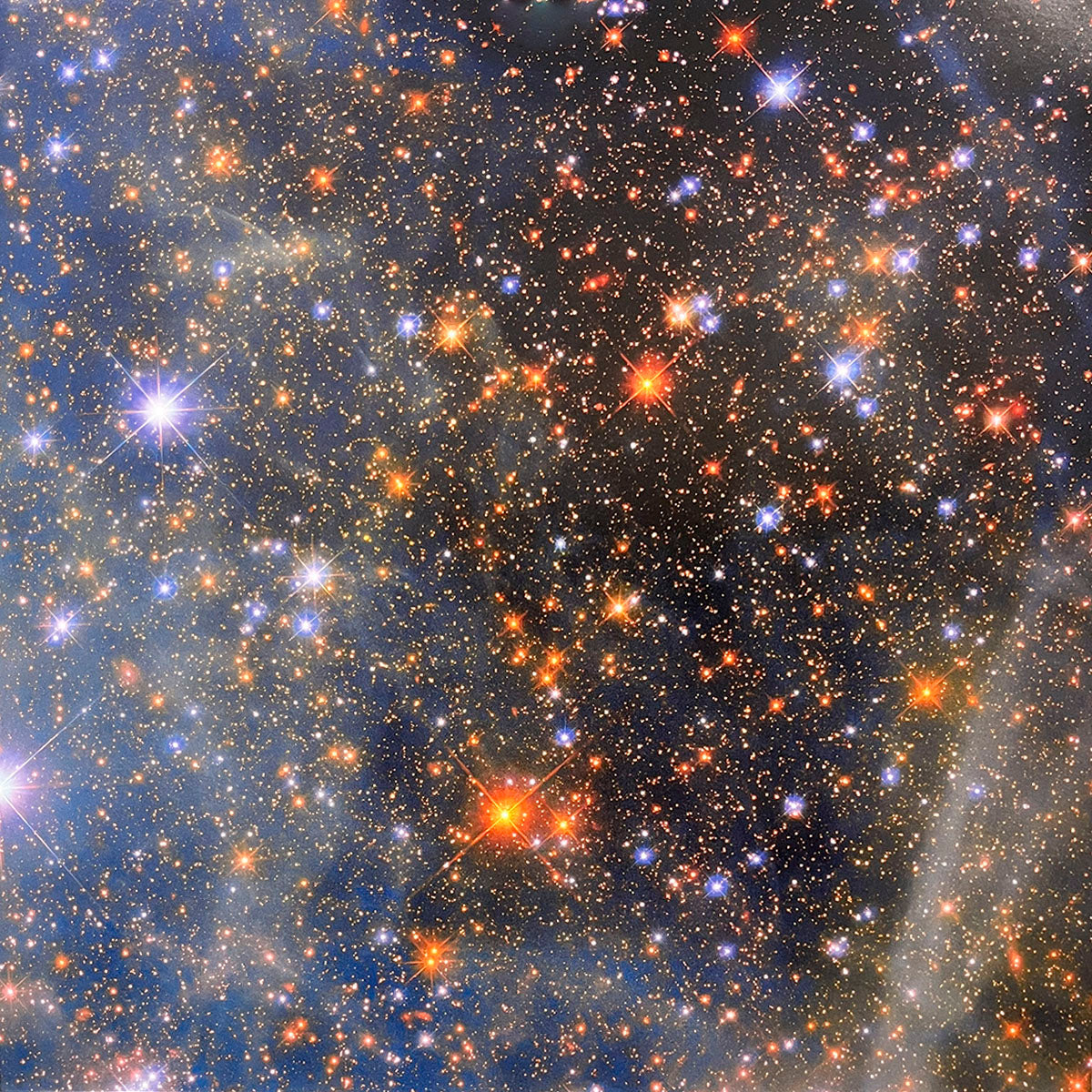Dense and shimmering field of colorful stars, showcasing a multitude of sparkling blues, oranges, and brilliant whites within a cosmic dust cloud.