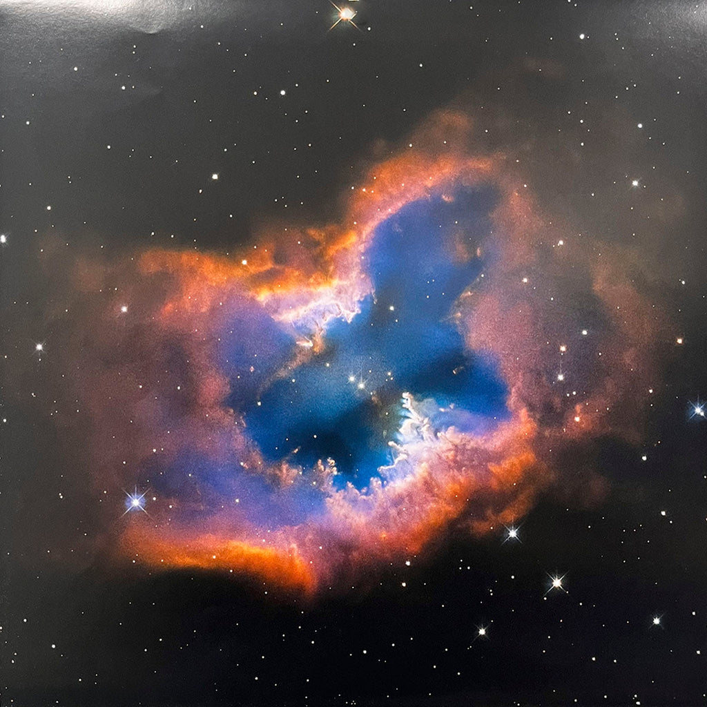Distinctive heart-shaped nebula, glowing intensely blue in its core, surrounded by warm orange and fiery red gas clouds.