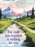 Vibrant acrylic painting magnet depicting a majestic mountain landscape with a winding path, a serene lake, and a glowing sunrise. The text 'The road less traveled is waiting for you' is prominently displayed in blue script, offering a message of encouragement and adventure.
