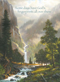 Inspirational religious magnet featuring a majestic natural landscape with a multi-tiered waterfall, a winding river, dense evergreen forests, and misty mountains. A deer grazes by the water, conveying peace and divine beauty. The text 'Some days have God's fingerprints all over them...' is prominently displayed, making it a perfect Christian gift or spiritual home decor accent.
