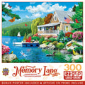 Memory Lane 300-piece EZ-grip jigsaw puzzle box featuring a picturesque lakeside cottage with an American flag, vibrant flowers, butterflies, a floating dock, swan, sailboat, and tranquil natural scenery, including a bonus poster.