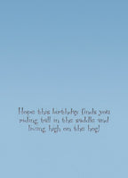 Inside text of funny birthday card with pig pun, printed on a light blue background: 'Hope this birthday finds you riding tall in the saddle and living high on the hog!'