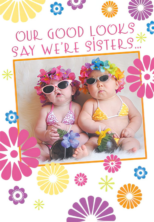 Two adorable babies in bikinis and flower crowns, with the text 'OUR GOOD LOOKS SAY WE'RE SISTERS...'. Vibrant floral border.