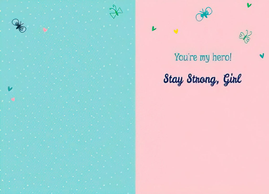 Inside of a cancer support greeting card. Left side is blank light blue. Right side features light pink background with small hearts and butterflies, and the message 'You're my hero! Stay Strong, Girl' in elegant blue script.