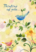 Front of a heartfelt greeting card featuring a blue bird and a pink bird on a vine with yellow and pink watercolor flowers on a soft yellow background, with text 'Thinking of you...'
