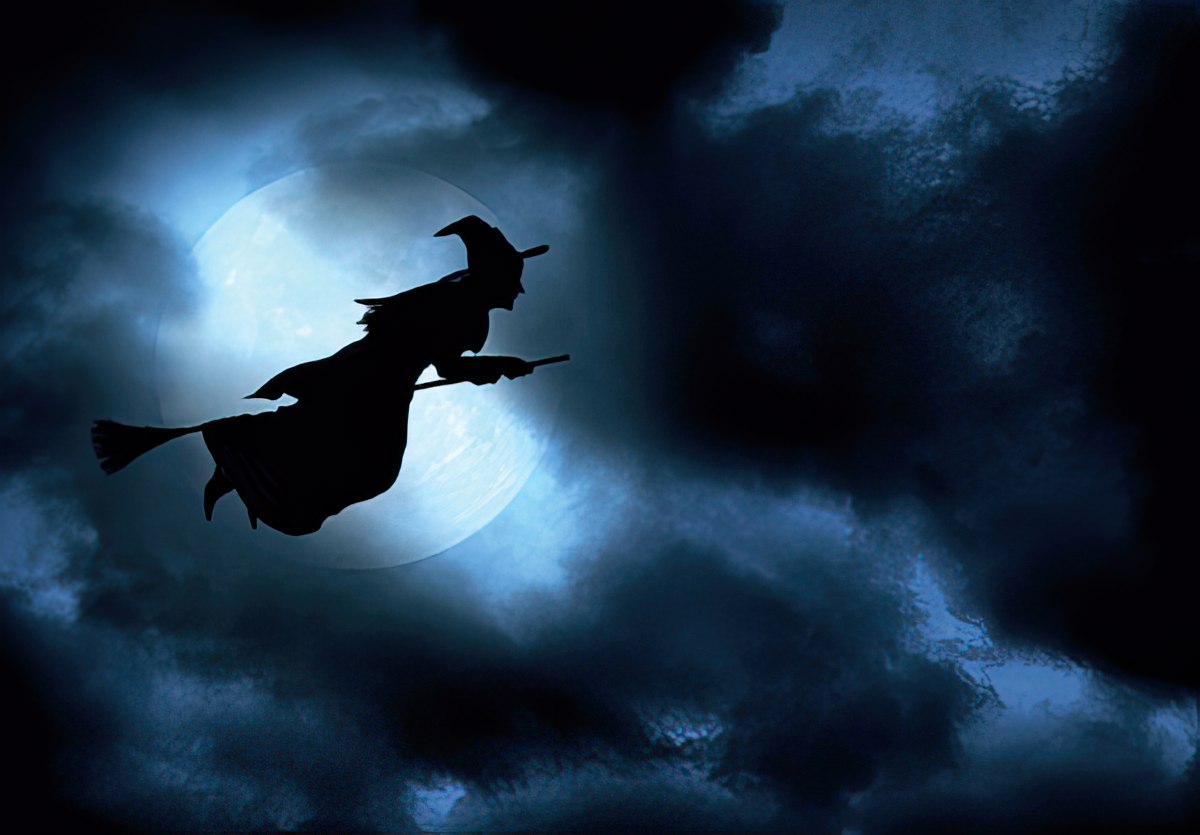 Witch flying on broom in night sky
