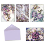Assorted hummingbird greeting cards by Jody Bergsma with blank lavender envelope. Shows four distinct watercolor designs featuring hummingbirds with fuchsias, morning glories, and petunias.