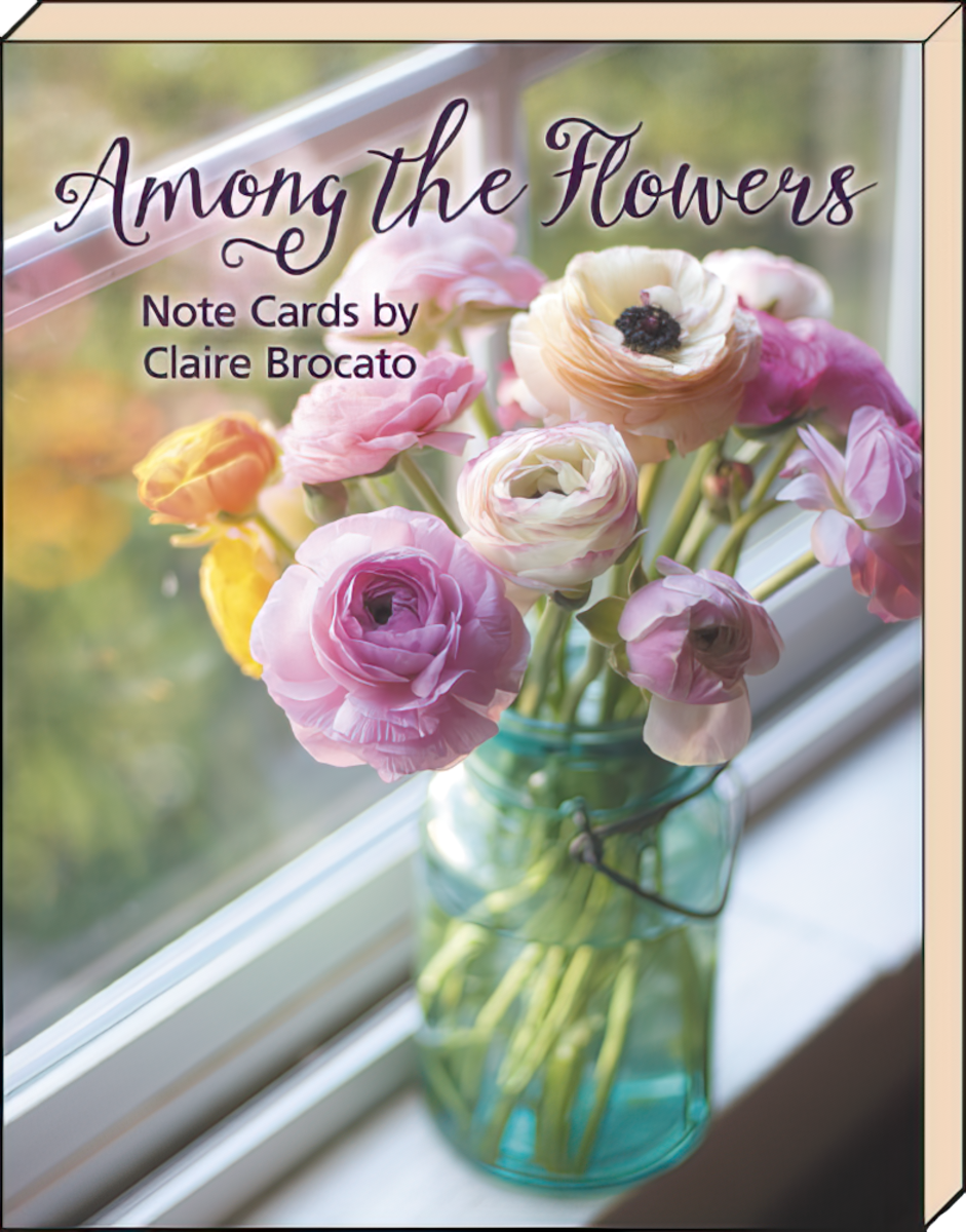 SEO-optimized alt description for an elegant greeting card showcasing three soft pink ranunculus blossoms arranged over vintage sheet music, perfect for a floral blank note card set.