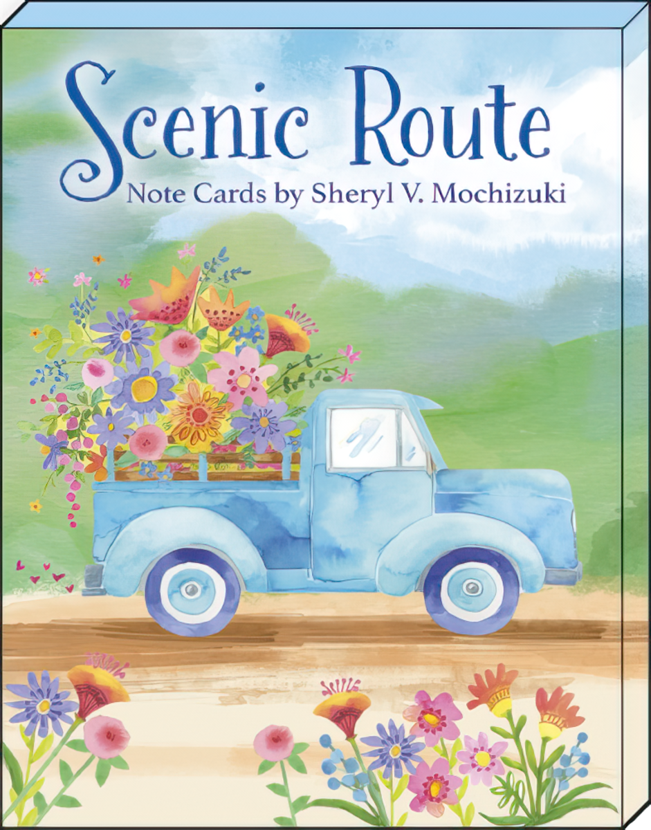 Front of 'Scenic Route Note Cards by Sheryl V. Mochizuki' box, showcasing a charming blue vintage pickup truck filled with a large bouquet of wildflowers against a serene landscape background.