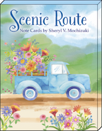 Front of 'Scenic Route Note Cards by Sheryl V. Mochizuki' box, showcasing a charming blue vintage pickup truck filled with a large bouquet of wildflowers against a serene landscape background.