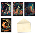 An assortment of four whimsical greeting cards and a blank cream envelope. Each card features a different woodland animal (rabbit, owl, hedgehog, fox) under a glowing crescent moon, surrounded by vibrant flowers and starry night skies. Designs are artistic and colorful.