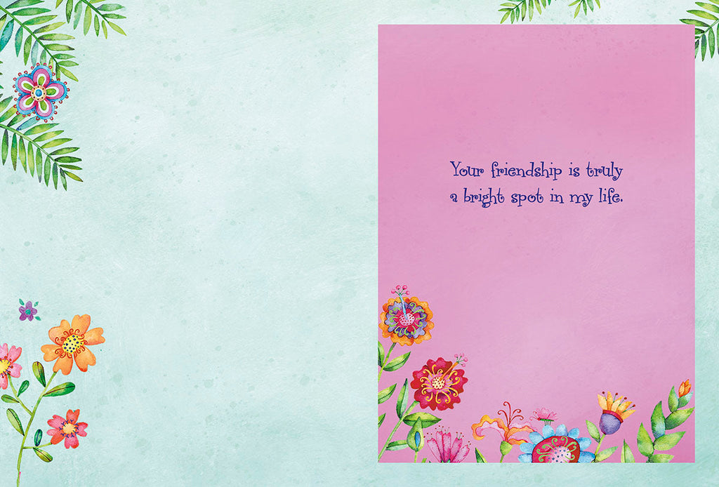 Inside view of a friendship card with a pink right page displaying 'Your friendship is truly a bright spot in my life' surrounded by whimsical flowers and a teal left page with floral accents.