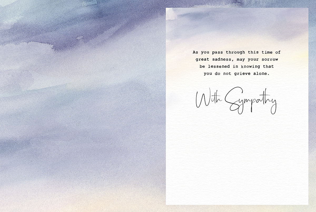 Open sympathy greeting card interior with a gentle watercolor background, showing a message of support and empathy: 'As you pass through this time of great sadness, may your sorrow be lessened in knowing that you do not grieve alone. With Sympathy.'