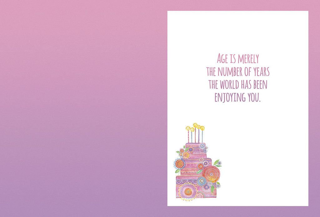 Open heartfelt greeting card interior with a colorful floral cake illustration and the message "AGE IS MERELY THE NUMBER OF YEARS THE WORLD HAS BEEN ENJOYING YOU." on a light purple background.