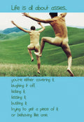 Humorous birthday greeting card featuring two nude men joyfully leaping in a grassy field under a blue sky, with text on the front: 'Life is all about asses... you're either covering it; laughing it off; kicking it; kissing it; busting it; trying to get a piece of it; or behaving like one.' A funny card for him or a friend.