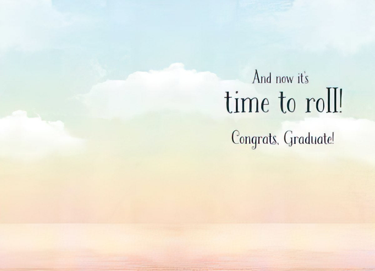 Inside of a congratulatory greeting card showing a light blue and peach sky background with clouds, and the celebratory message 'And now it's time to roll! Congrats, Graduate!' in elegant script.