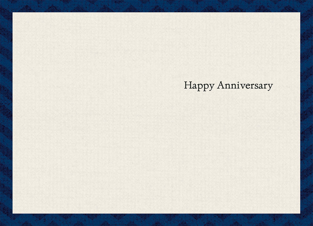 Inside of a thoughtful anniversary greeting card, subtly textured, with elegant black text reading 'Happy Anniversary' centered on the right side.