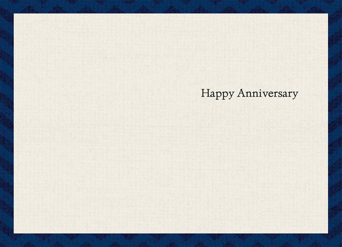 Inside of a thoughtful anniversary greeting card, subtly textured, with elegant black text reading 'Happy Anniversary' centered on the right side.
