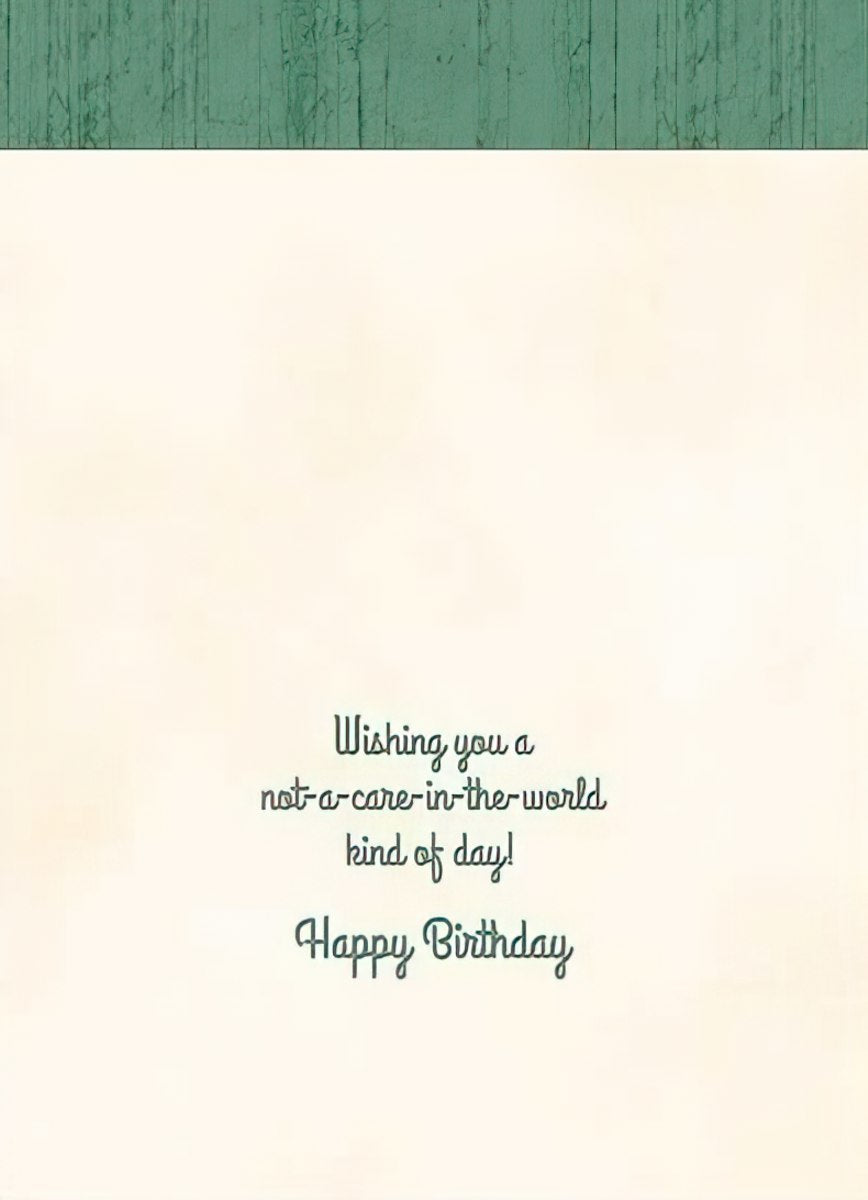 Inside view of a birthday card with the heartfelt message 'Wishing you a not-a-care-in-the-world kind of day! Happy Birthday' in elegant script, against a cream background with a subtle green woodgrain top border, ready for a personalized touch.