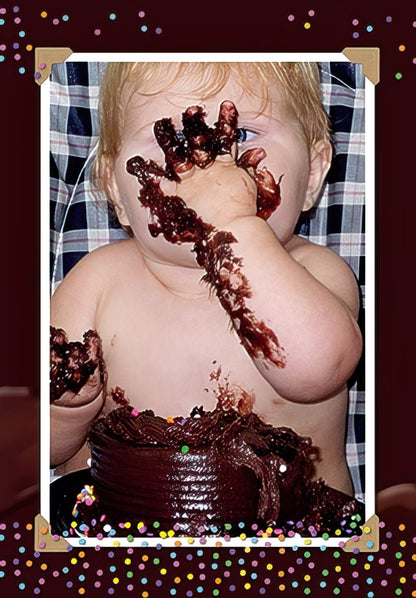 Adorable baby covered in chocolate cake, hands messy, celebrating first birthday with a joyful expression. Funny birthday card design.