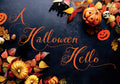 Decorative Halloween greeting card cover featuring illuminated pumpkins, autumn leaves, a black bat, and a small skull on a dark background, with elegant orange script reading 'A Halloween Hello', perfect for sending festive wishes.
