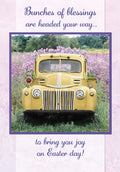 Religious Easter greeting card featuring a vintage yellow pickup truck surrounded by vibrant purple flowers, delivering blessings and joy for the holiday.