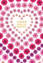 Front of a beautiful greeting card featuring a heart shape formed by concentric circles of vibrant pink and purple daisy flowers. The text 'LOVE MAKES LIFE BEAUTIFUL' is centered within the heart, on a white background.