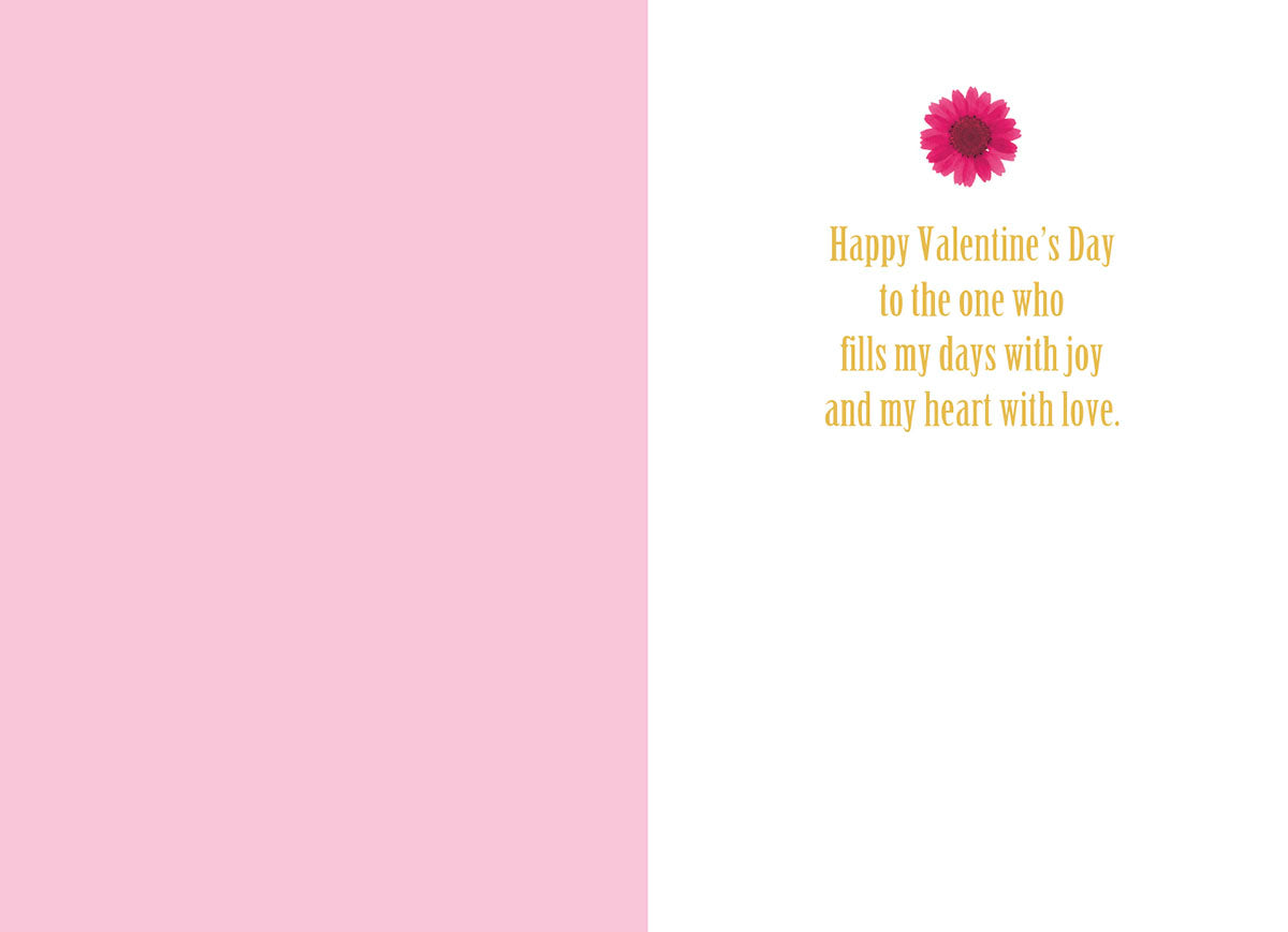 Inside view of a romantic greeting card, showing a light pink left panel and a white right panel with a single pink daisy illustration. The heartfelt message reads: 'Happy Valentine's Day to the one who fills my days with joy and my heart with love.'