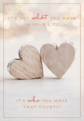 Front of a heartfelt greeting card featuring two rustic wooden hearts and romantic text: 'It's not what you have in your life, it's who you have that counts!' perfect for a spouse or loved one.