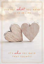 Front of a heartfelt greeting card featuring two rustic wooden hearts and romantic text: 'It's not what you have in your life, it's who you have that counts!' perfect for a spouse or loved one.