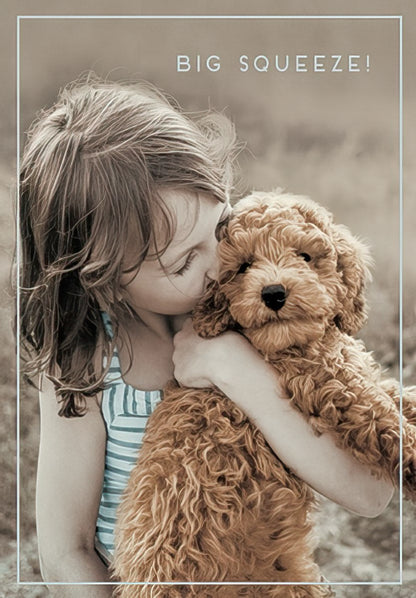The front of a sweet card featuring a child affectionately hugging a fluffy brown puppy, with "BIG SQUEEZE!".