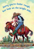 Humorous greeting card front featuring a cartoon cowboy looking dejected on a tired donkey with text 'Sorry you're feelin' rough, but look on the bright side...' for a him, friend, or coworker.