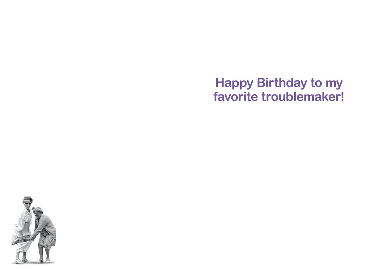 Inside of a humorous birthday card with purple text 'Happy Birthday to my favorite troublemaker!' and a small image of two old women at the bottom.